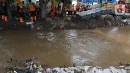 Petugas Suku Dinas Sumber Daya Air (Sudin SDA) Jakarta Timur menutup luapan air dari tanggul menggunakan tumpukan karung-karung pasir. (merdeka.com/Imam Buhori)