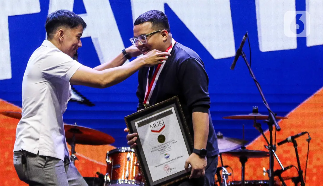Museum Rekor Indonesia (MURI) memberikan piagam penghargaan atas pencapaian rekor muri pajangan swafoto Polaroid terbanyak oleh pelajar di acara KapanLagi Pensi Bareng Fanta 2025 yang digelar di Gelanggang Olahraga (GOR) atau Gelanggang Mahasiswa Soemantri Brodjonegoro, Jakarta, Sabtu (28/6/2025). (Liputan6.com/Herman Zakharia)