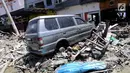 Sebuah mobil Mitsubishi Kuda menjadi incaran jarahan korban gempa dan tsunami di Palu Grand Mal, Palu, Jumat (5/10). Warga korban gempa bumi mengambil ban dan interior mobil. (Liputan6.com/Fery Pradolo)