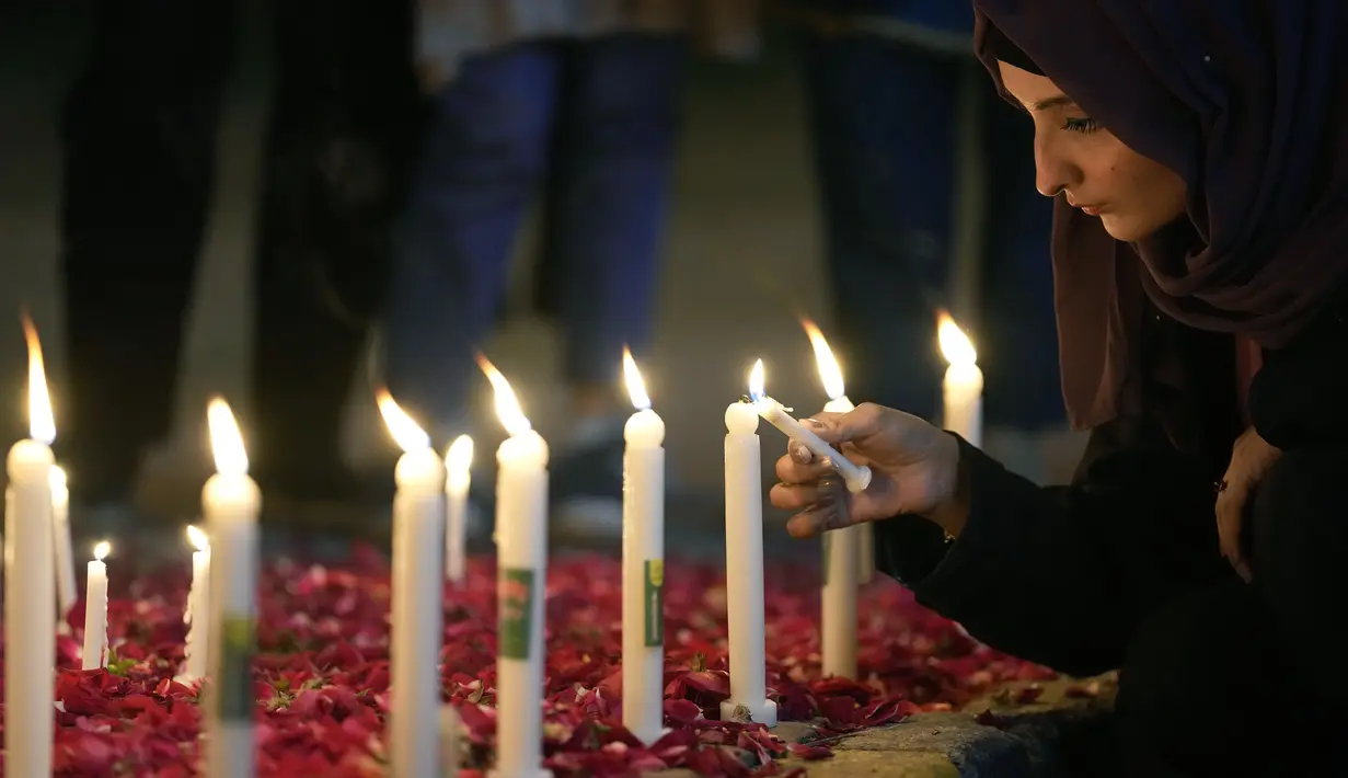 Seorang perempuan menyalakan lilin untuk para korban gempa bumi di Suriah dan Turki, di Islamabad, Pakistan, Senin, 6 Februari 2023. Gempa berkekuatan M7,8 telah mengguncang sebagian besar wilayah Turki dan Suriah. (AP Photo/Anjum Naveed)
