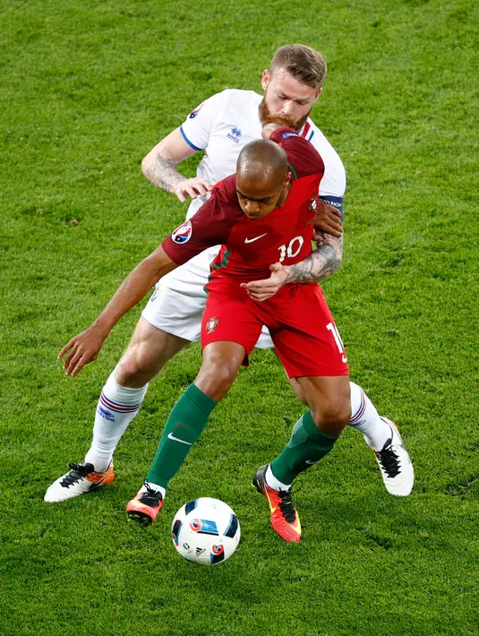 Gelandang Portugal, Joao Mario (depan) mengontrol bola dari kawalan gelandang Islandia, Aron Gunnarsson pada laga Grup F Piala Eropa di Stade Geoffroy-Guichard, Prancis, Selasa (14/6). Islandia berhasil tahan imbang Portugal 1-1. (REUTERS/Max Rossi)