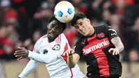 Pemain Bayer Leverkusen, Piero Hincapie, duel udara dengan pemain Union Berlin, David Datro Fofana, pada laga Bundesliga di Bay Arena, Minggu (12/11/2023). (AFP/Ina Fassbender)