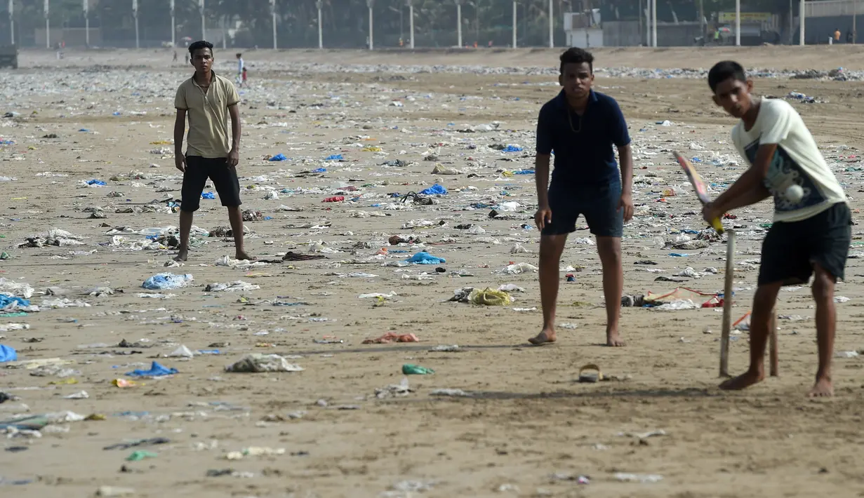 Sejumlah pemuda India bermain kriket dengan dipenuhi sampah plastik di pantai Juhu di Mumbai, (2/6). (AFP PHoto/Punit Paranjpe)