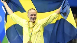 Sarah Sjostrom memegang bendera Swedia di atas podium setelah meraih medali emas renang nomor 100 meter gaya kupu-kupu pada Olimpiade 2016 di Rio de Janeiro, Minggu (7/8). Sjostrom memecahkan rekor dunianya atas namanya sendiri (GABRIEL Bouys/AFP)