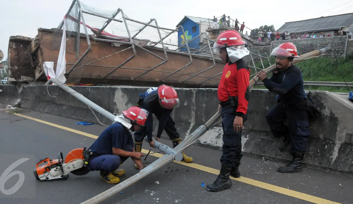 Petugas pemadam kebakaran membantu evakuasi Jembatan Penyeberangan Orang (JPO) yang roboh usai ditabrak truk trailer di KM 7.600 Tol BSD, Tangsel, Senin (16/5). Dua unit mobil crane digunakan untuk membantu evakuasi. (Liputan6.com/Helmi Afandi)