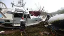 Bradley Mitchell memeriksa perahu usai diterjang Topan Debbie di Shute Harbour, Pantai Airlie, Australia, Rabu (29/3). Badai yang mengembuskan angin hingga 161 km per jam memporak-porandakan puluhan bangunan di pesisir. (Dan Peled/AAP Image via AP)