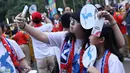 Pendukung tim Korea Bersatu berswafoto jelang menyaksikan seremoni pembukaan Asian Games 2018 di Stadion GBK, Jakarta, Sabtu (18/8). Asian Games 2018 akan berlangsung hingga 2 September, mendatang. (Liputan6.com/Helmi Fithriansyah)