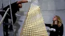 Karyawan dari rumah emas ProAurum menyusun koin emas yang disebut sebagai pohon Natal di Munich, Jerman, 3 Desember 2018. Pohon Natal ini terbuat dari 2.018 koin emas filharmonik wina ini memiliki berat 63 kilogram emas murni. (AP/Matthias Schrader)