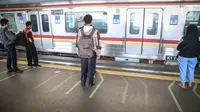Penumpang berdiri di garis antrean penumpang di Stasiun Juanda, Jakarta, Kamis (10/8). PT KAI Commuter Jabodetabek melakukan uji coba garis antrean penumpang tersebut guna untuk keselamatan bagi para penumpang. (Liputan6.com/Faizal Fanani)