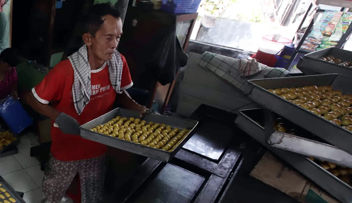 Pekerja menyelesaikan pembuatan kue kering skala rumah tangga Pusaka Kwitang di kawasan Senen, Jakarta, Rabu (13/4/2022). Pedagang mengaku terpaksa menaikkan harga jual kue kering Ramadhan akibat tingginya harga bahan baku. (Liputan6.com/Herman Zakharia)