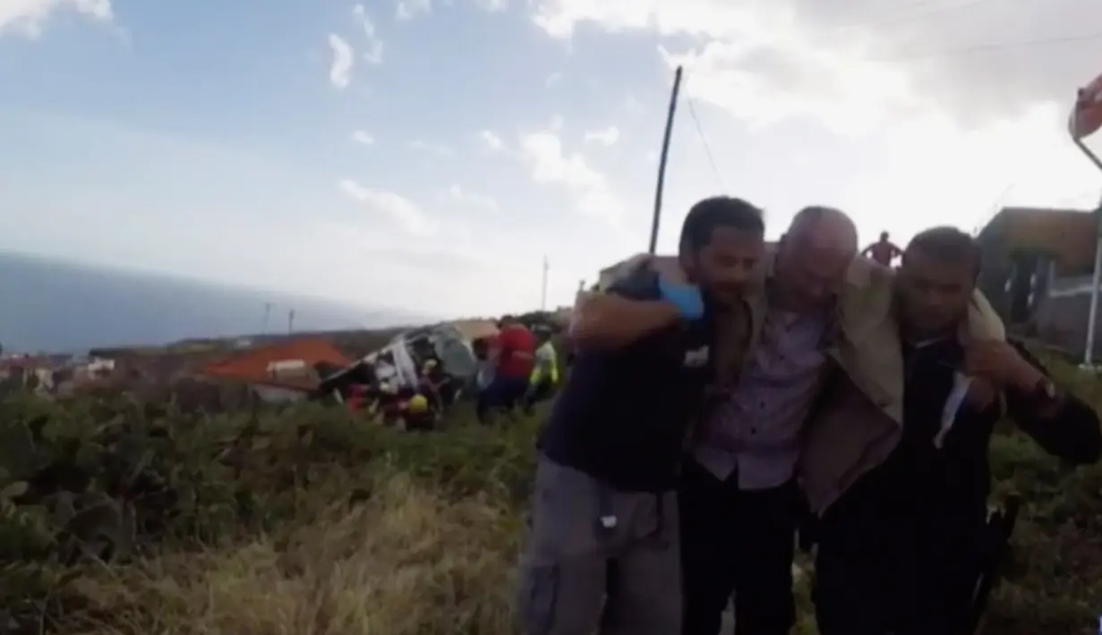 Petugas penyelamat mengevakuasi korban kecelakaan sebuah bus pariwisata yang terguling di Kota Canico, Pulau Madeira, Portugal, Rabu (17/4). Polisi setempat menyatakan belum mengetahui apakah ada korban tewas selain penumpang bus. (TVI via AP)