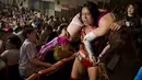 Pegulat Mieko Satomuran mengangkat lawannya Kairi Hojo melalui tribun penonton pada pertandingan gulat wanita profesional di Tokyo , Jepang , (26/7/2015).Wanita tersebut bergulat untuk mendapatkan gelar World Wonder Ring Stardom. (REUTERS / Thomas Peter)