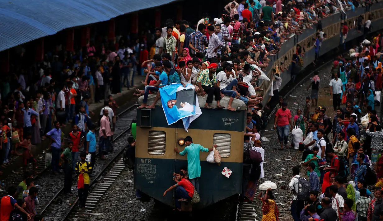 Ribuan orang tampak berdesakan menaiki atap kereta di sebuah stasiun, Dhaka, Bangladesh, Selasa (5/7). Mereka rela bersesakan untuk menuju kampung halaman pada Hari Raya Idul Fitri kali ini. (REUTERS / Adnan Abidi)