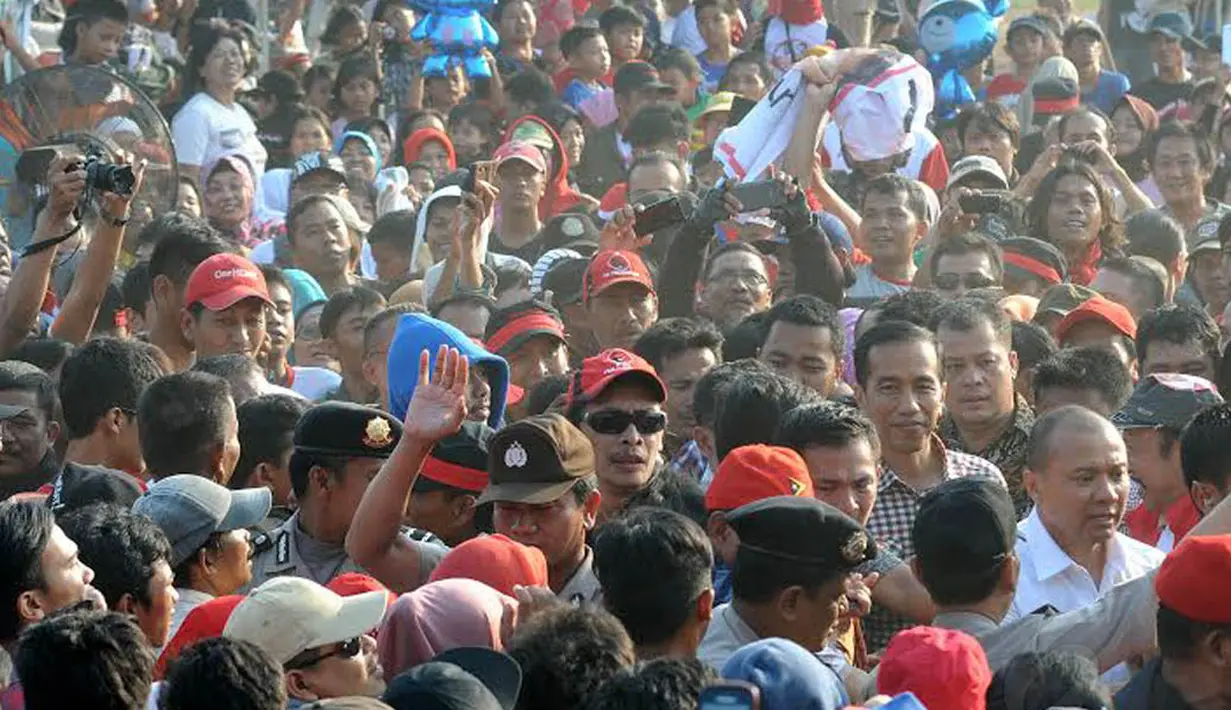 Jokowi tampak tersenyum saat menerobos lautan manusia yang telah menunggu sejak pagi (Liputan6.com/Herman Zakharia)