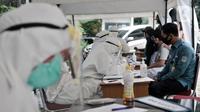 Petugas medis mendata peserta sebelum menjalani tes swab COVID-19 di Kantor Kecamatan Kramat Jati, Jakarta, Selasa (16/6/2020). Puskesmas Kecamatan Kramat Jati menggelar tes swab bagi seluruh pegawai instansi pemerintahan untuk memutus rantai penyebaran COVID-19. (merdeka.com/Iqbal Nugroho)