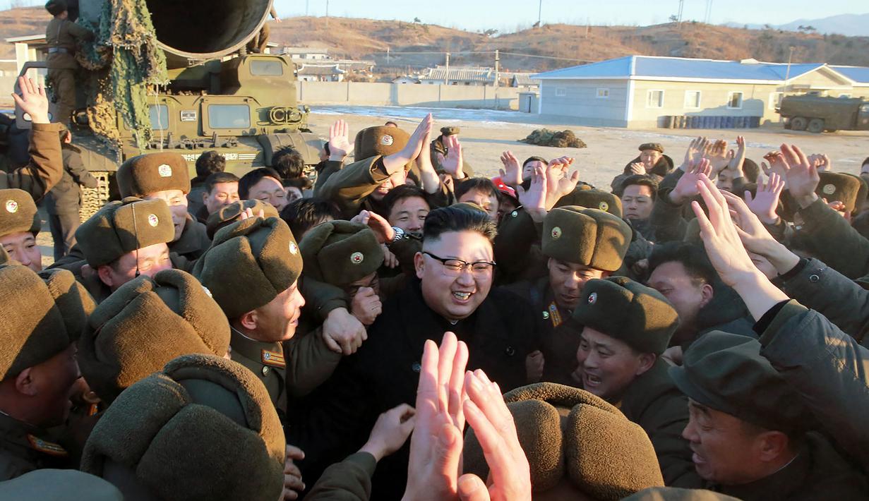 Pemimpin Korea Utara, Kim Jong Un bersama tentaranya usai memimpin peluncuran rudal Pukguksong-2, Minggu (12/2). Kim mengaku puas pada hasil uji coba yang dilakukannya. (AFP PHOTO/KCNA)  