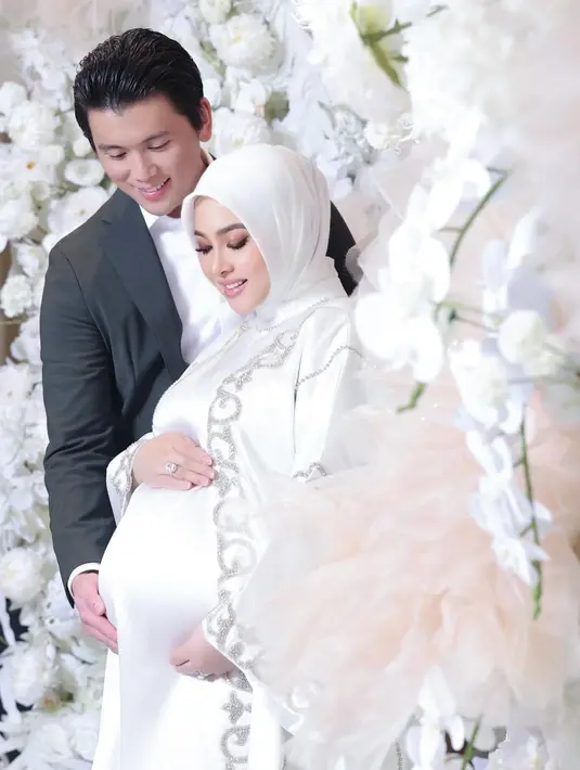 Syahrini dan Reino Barack tampil formal dengan busana putih hitam. Syahrini kenakan dress dan outer putih dengan bordir silver. Sedangkan Reino Barack pilih gaya semi formal dengan setelan putih dan jas abu-abu. [@princessyahrini]