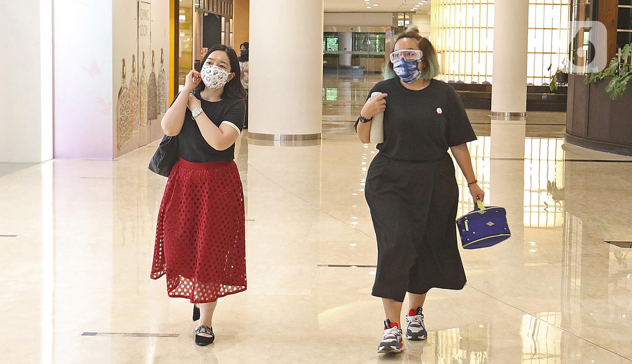 Pengunjung dengan mengenakan masker berkeliling Mall Senayan City, Jakarta, Senin (15/6/2020). Pusat perbelanjaan atau mal di Jakarta kembali dibuka pada Senin (15/6) di masa PSBB transisi dengan jumlah pengunjung masih dibatasi hanya 50 persen dari kapasitas normal. (Liputan6.com/Herman Zakharia)