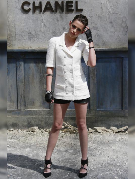 Saat Kristen Stewart hadir di acara Chanel Paris Fashion Show, ia terlihat sangat cantik dengan memakai Blazer putih karya Chanel yang di padukan dengan celana pendek hitam dan wedges hitam.  (www.ibtimes.co.uk)