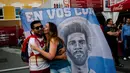 Seorang suporter Argentina mencium kekasihnya saat berada di jalanan Nizhny Novgorod, Selasa (19/6/2018). Cerita sepenggal kisah romantis saat Piala Dunia 2018 Rusia. (AFP/Dimitar Dilkoff)