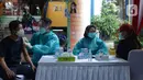 Polisi menyuntikkan vaksin virus corona COVID-19 kepada pedagang Pasar Induk Kramat Jati di Jakarta Timur, Kamis (22/7/2021). Sebanyak 250 pedagang Pasar Induk Kramat Jati menjalani vaksinasi guna menekan penyebaran COVID-19. (merdeka.com/Imam Buhori)
