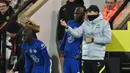 Penyerang Chelsea, Romelu Lukaku mendapatkan instruksi dari Thomas Tuchel sebelum masuk ke lapangan sebagai pemain pengganti dalam pertandingan lanjutan Liga Inggris 2021/2022 antara Norwich City melawan Chelsea, 10 Maret 2022. (AFP/Glyn Kirk)