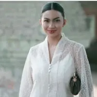 Ariel Tatum tampil serba putih, mengenakan atasan kebaya modern bermotif transparan dipadukan inner spaghetti strap warna senada. Tampak ia pun membawa shoulder bag hitam. [@arieltatum]