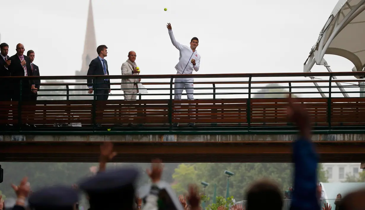 Petenis Serbia, Novak Djokovic melemparkan bola kepada fans setelah mengalahkan petenis Swiss, Roger Federer di babak final tunggal putra Wimbledon 2015, London, Minggu (12/7). Ini adalah gelar Wimbledon ketiga bagi Djokovic.  (REUTERS/Stefan Wermuth)