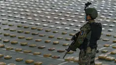 Anggota Layanan Perbatasan Nasional Panama menjaga paket ganja sitaan saat konferensi pers di Pangkalan Senafront Gamboa, Panama City, Panama, 1 September 2019. Militer Panama menyita 785 kilogram ganja selama operasi antinarkotika di perbatasan maritim dengan Kolombia. (Luis Acosta/AFP)