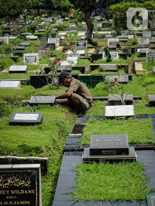 Petugas membersihkan makam yang ada di TPU Karet Bivak, Jakarta, Kamis (4/3/2021). Komisi D DPRD DKI Jakarta meminta menyederhanakan proses izin perpanjangan sewa makam karena proses birokrasi yang rumit dan dianggap mempersulit ahli waris. (Liputan6.com/Faizal Fanani)