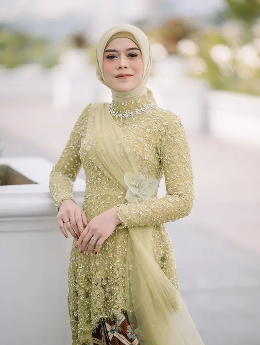Kebaya modern full payet warna hijau kekuningan membuat Lesti Kejora semakin bersinar. Aksen bunga Anggrek Cattleya di bagian pinggang dari kebaya rancangan Renzi Lazuardi juga menambah daya tarik tersendiri. [@renzilazuardi]