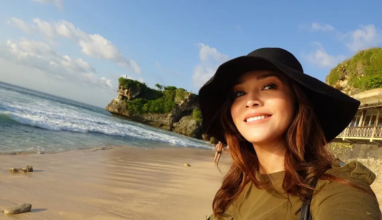 Kebahagiaan terpancar dari raut wajah Maia Estianty. Berfoto selfie di pantai, mengenakan topi lebar berwarna hitam, Maia terlihat cantik natural dengan riasan dan lipstik nude. Foto: Instagram.