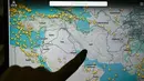 Per 1 Maret 2026, wilayah udara Iran dan Irak ditutup sepenuhnya untuk penerbangan sipil menyusul eskalasi militer besar-besaran Amerika Serikat dan Israel. Tampak dalam foto, seseorang menunjuk ke halaman di situs web Flightradar 24 yang menunjukkan penerbangan sipil menghindari wilayah udara Iran dan Irak, di Paris pada Minggu 1 Maret 2026. (Anna KURTH/AFP)
