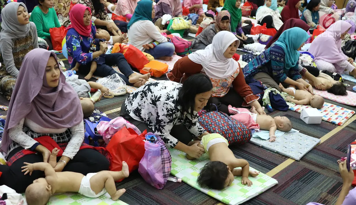 Para peserta mengikuti acara pijat massal bayi di Gedung Kementerian Kesehatan, Jakarta, Selasa (7/11). Acara tersebut digelar dalam rangka menyambut peringatan Hari Kesehatan Nasional ke-53. (Liputan6.com/Immanuel Antonius)