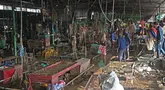 Para pedagang membersihkan lumpur dan puing-puing di sebuah pasar sayur di daerah yang terkena dampak banjir setelah hujan lebat di Kathmandu pada tanggal 29 September 2024. (PRAKASH MATHEMA/AFP)
