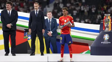 Penyerang Spanyol, Lamine Yamal menerima trofi pemain muda terbaik setelah memenangkan pertandingan final Euro 2024 melawan Inggris di Olympiastadion, Berlin pada 14 Juli 2024. (Adrian DENNIS/AFP)