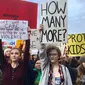 Sejumlah siswa dari Roosevelt High School membawa poster saat melakukan aksi di Seattle (14/3). Ini merupakan aksi terbesar pasca penembakan di sebuah SMA di Parkland, Florida, yang menewaskan 17 orang. (AP Photo / Manuel Valdes)