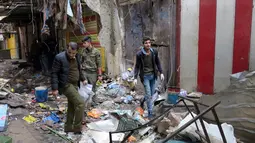Petugas keamanan Irak memeriksa lokasi serangan bom yang terjadi di sebuah pasar di Baghdad, Irak (31/12). Sedikitnya 21 orang dilaporkan tewas dan 40 orang terluka. (Reuters/Ali al-Mashhadan )