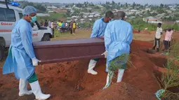Petugas yang mengenakan pakaian pelindung menurunkan peti mati seorang anak berusia enam tahun yang meninggal akibat Ebola saat pemakaman di Bunia, Provinsi Ituri, Kongo timur, Selasa, 18 Agustus 2026. (Foto AP/Dieudonne Dirole)