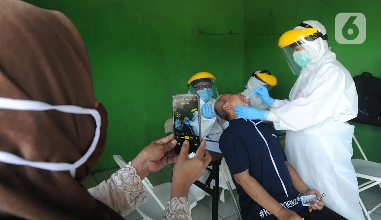 Petugas medis dari Pemkot Jakarta Selatan melakukan tes swab Covid-19 para pedagang  di Pasar Sayur Cipulir, Jakarta Selatan, Kamis (25/6/2020). Kegiatan yang dilakukan kepada puluhan pedagang dan warga seputar pasar ini dalam rangka memutus mata rantai penyebaran Covid-19. (merdeka.com/Arie Basuki)