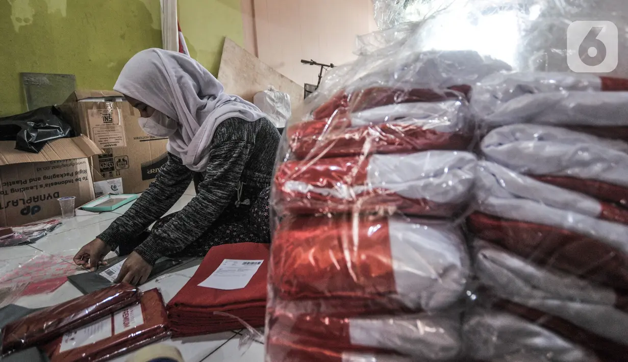 Pekerja mengemas bendera Merah Putih untuk diikirim melalui jasa kurir di industri rumahan benderaindonesia.com, Jakarta, Selasa (3/8/2021). Andri (56) seorang pemilik toko bendera online ini mengaku dalam sehari mampu menjual hingga 100 buah bendera Merah Putih. (merdeka.com/Iqbal S Nugroho)