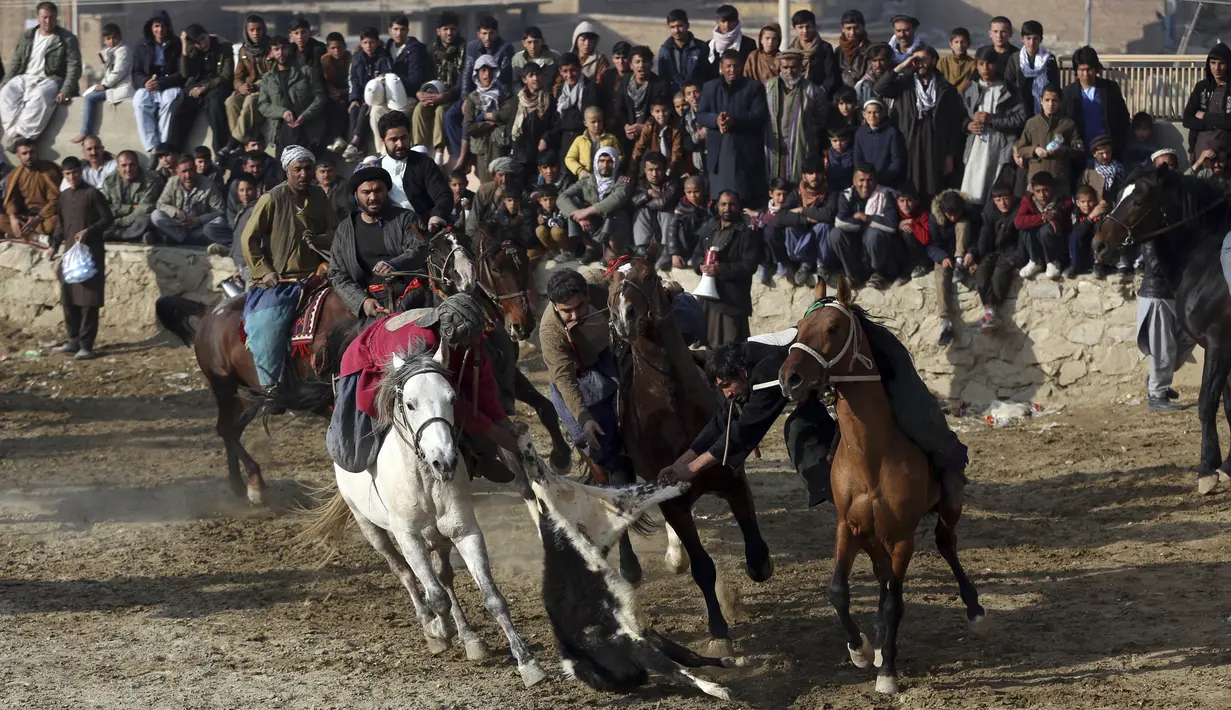 Penunggang kuda berebut kambing pada pertandingan persahabatan buzkashi di pinggiran Kabul, Afghanistan, Jumat (27/12/2019). Olahraga ini sempat dilarang selama pemerintahan Taliban. (AP Photo/Rahmat Gul)