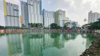 Kondisi Danau Sunter yang berwarna hijau di Jakarta Utara pada Senin (8/7/2019). Lamanya musim kemarau di Ibu kota menjadi penyebab danau tersebut berubah warna menjadi hijau yang dipicu oleh pertumbuhan lumut. (Liputan6.com/Immanuel Antonius)