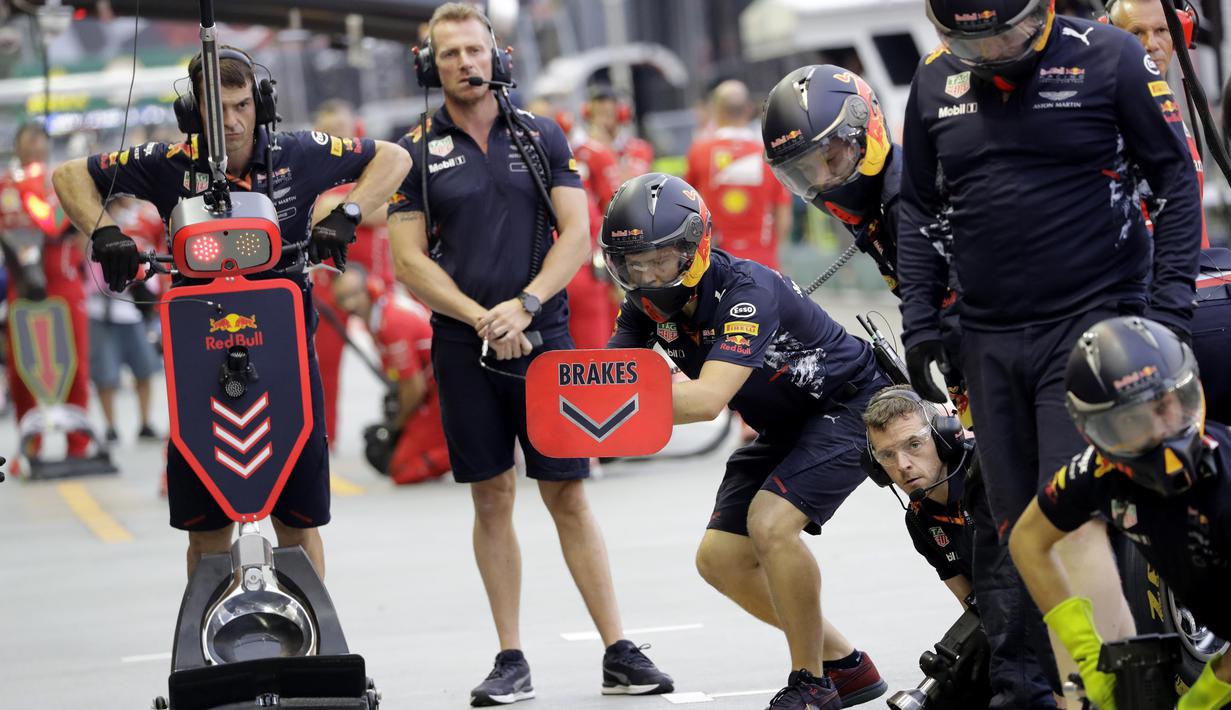 Mekanik Red Bull bersiap menanti kedatangan pebalap Max Verstappen pada sesi latihan bebas F1 GP Singapura di Marina Bay City Circuit, (15/9/2017). (AP/Wong Maye-E)