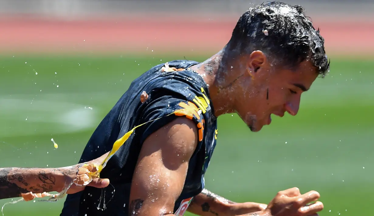 Ekspresi pemain sepak bola Brasil, Coutinho saat diceploki telur dan tepung oleh rekan-rekannya dalam sesi latihan jelang Piala Dunia 2018 di Sochi, Rusia, Selasa (12/6). (Nelson Almeida/AFP)