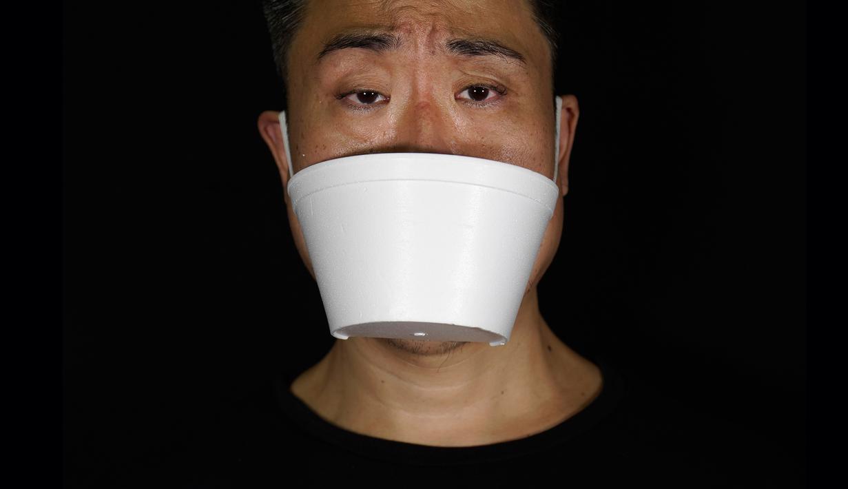 Edmond Kok, aktor dan desainer kostum teater Hong Kong, mengenakan masker wajah yang terbuat dari wadah take away di Hong Kong pada 6 Agustus 2020. Sepanjang pandemi, Edmond telah membuat lebih dari 170 masker yang terinspirasi oleh pandemi dan masalah politik Hong Kong. (AP Photo/Vincent Yu)