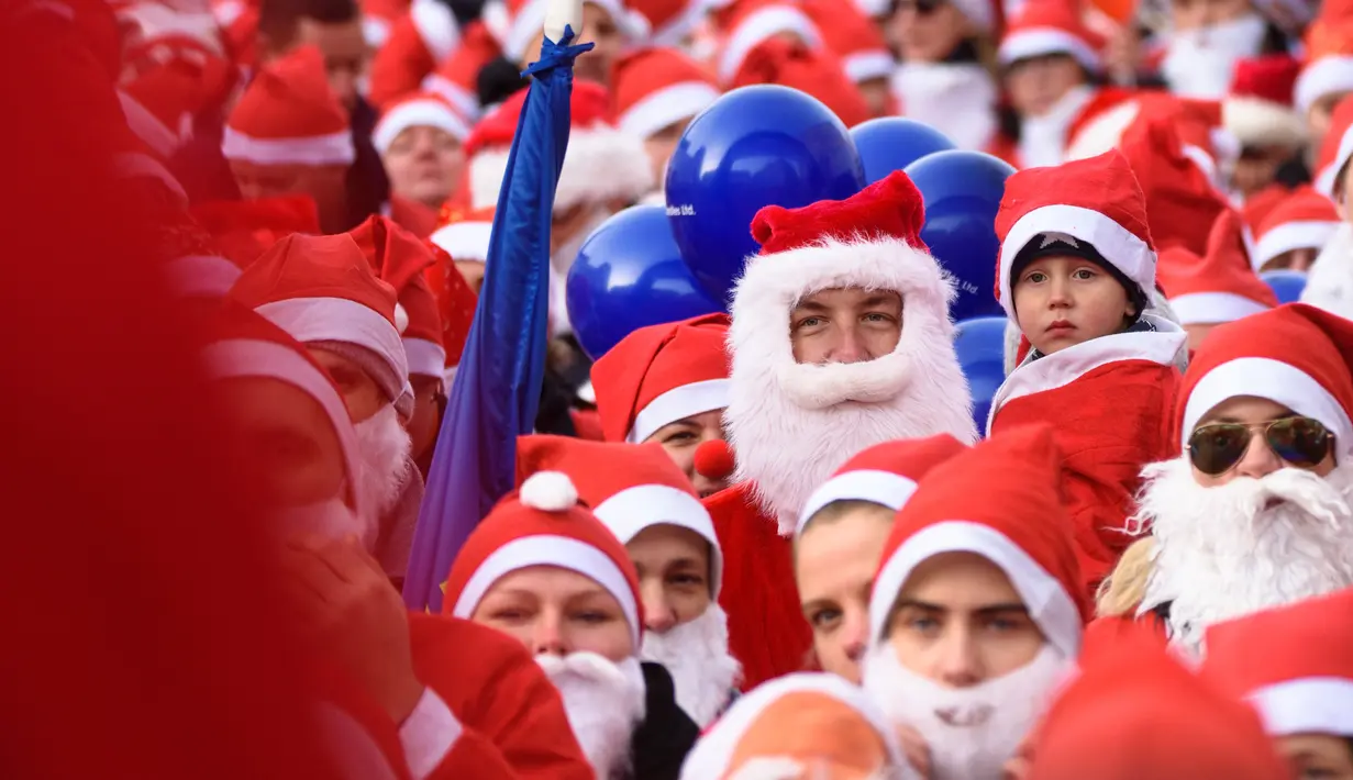 Peserta mengambil bagian dalam Santa's Fun Run di Riga, Latvia, Minggu (8/12/2019). Ini merupakan acara amal yang pesertanya bersenang-senang dengan berlari atau berjalan kaki sambil mengenakan kostum Sinterklas untuk mengumpulkan dana bagi anak-anak di rumah sakit Latvia. (Gints Ivuskans/AFP)
