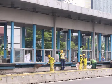 Sejumlah petugas membersihkan puing Halte Bus TransJakarta Tosari yang dirusak saat kericuhan unjuk rasa menolak pengesahan UU Cipta Kerja di Jakarta, Jumat (9/10/2020). Sejumlah fasilitas umum rusak dalam kericuhan yang terjadi Kamis (8/10). (Liputan6.com/Angga Yuniar)