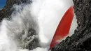 Reaksi ledakan saat lava meluncur ke air laut di Samudra Pasifik, Hawaii, Rabu (1/2). Fenomena mengalirnya lava bak air terjun ini menjadi daya tarik wisatawan. (Shane Turpin / Lava Ocean Tours via AP)