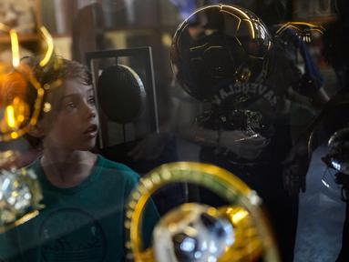 Seorang anak laki-laki terpantul pada kotak kaca saat ia mengunjungi Museum Pele di Santos, Brasil, 26 Desember 2022. Museum Pele secara resmi dibuka pada 15 Juni 2014. (AP Photo/Matias Delacroix)